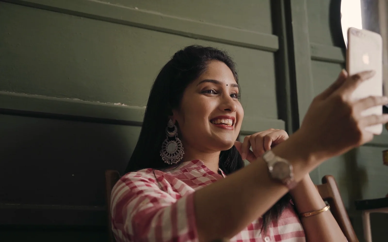 A young woman taking a selfie in a café